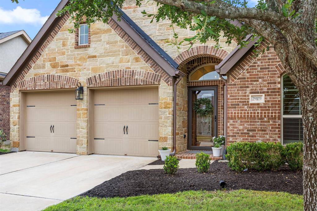 Stunning brick and rock exterior elevation with perfectly maintained landscaping and mature trees.