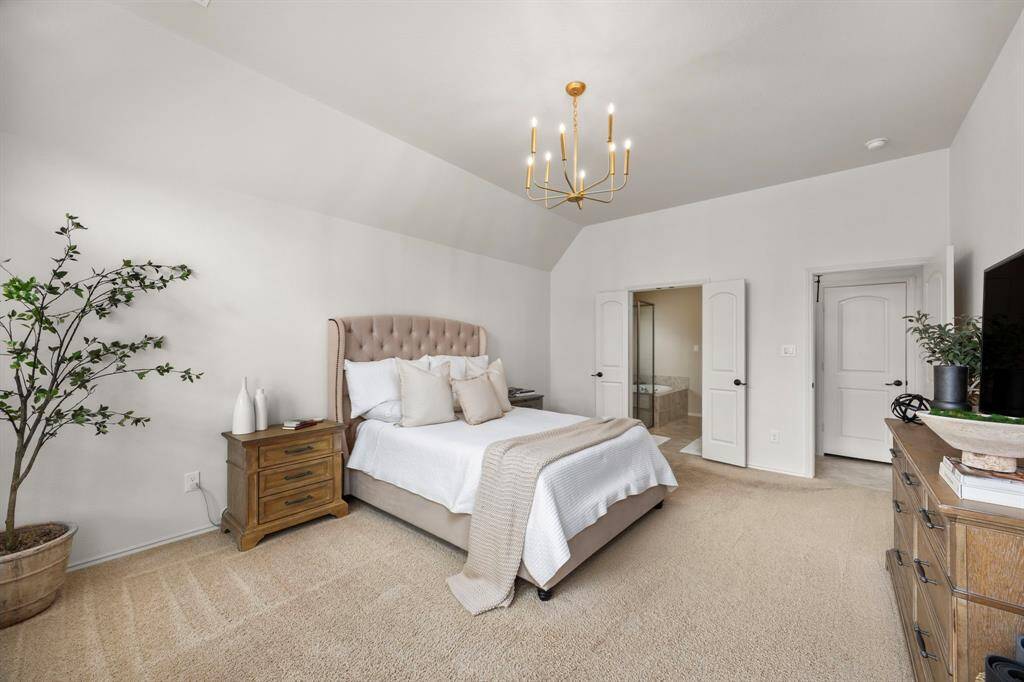 Lovely primary bedroom with high ceilings and plush carpet.