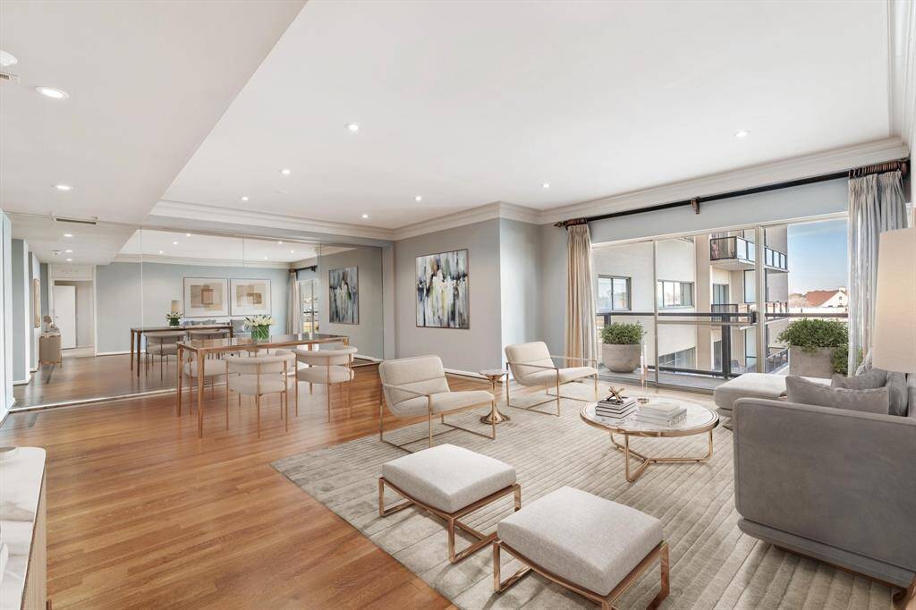 Living room looking towards the dining room and balcony. The space will accommodate large scale furnishings. Image shown virtually staged.