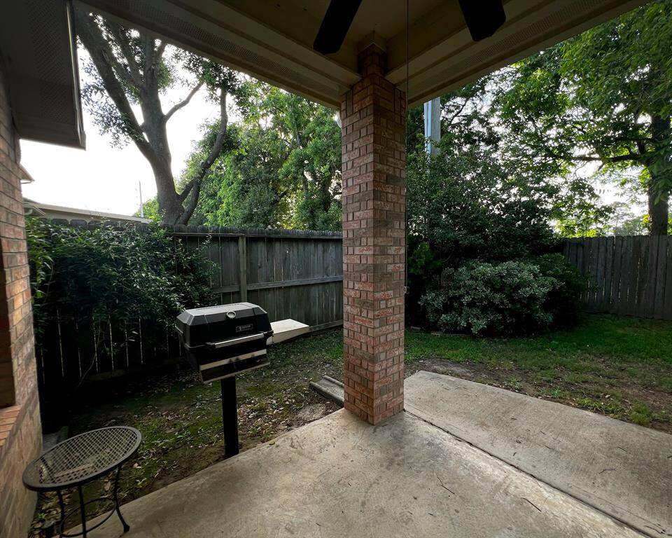 The extended, covered back patio area provides an attached gas grill for outdoor cooking, impressive brick columns, and three ceiling fans.