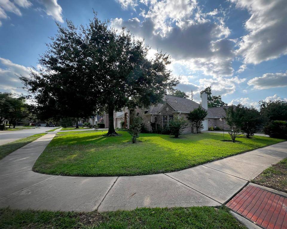 Spacious corner lot with lush green yard, large shade tree, and sidewalks to keep you out of the road on your daily walks.