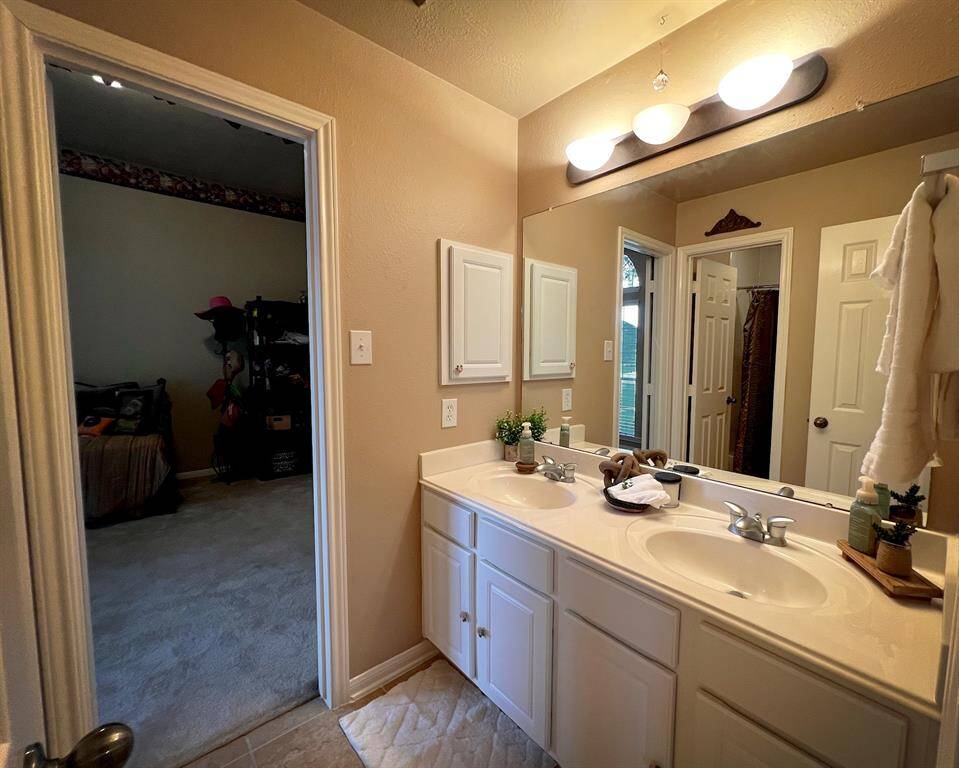 This full size bathroom has private access from each of the secondary bedrooms, utilizing dual sinks and plenty of storage space.