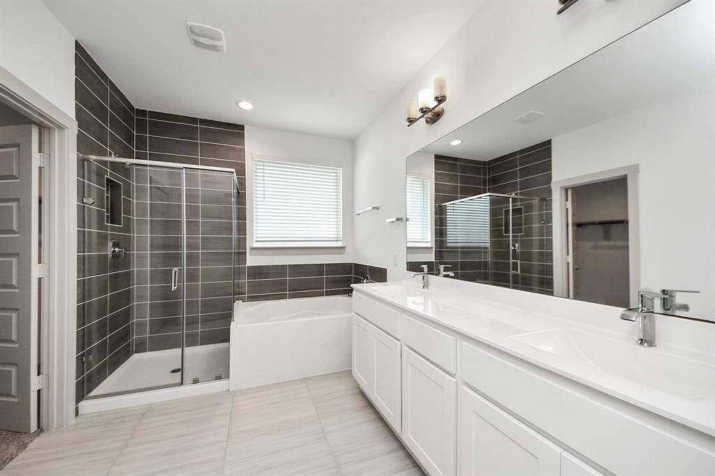 Masterpiece of relaxation! This exquisite master bathroom shines with stunning tile work, ample natural light, and a spacious layout, creating a serene oasis perfect for unwinding and rejuvenating!