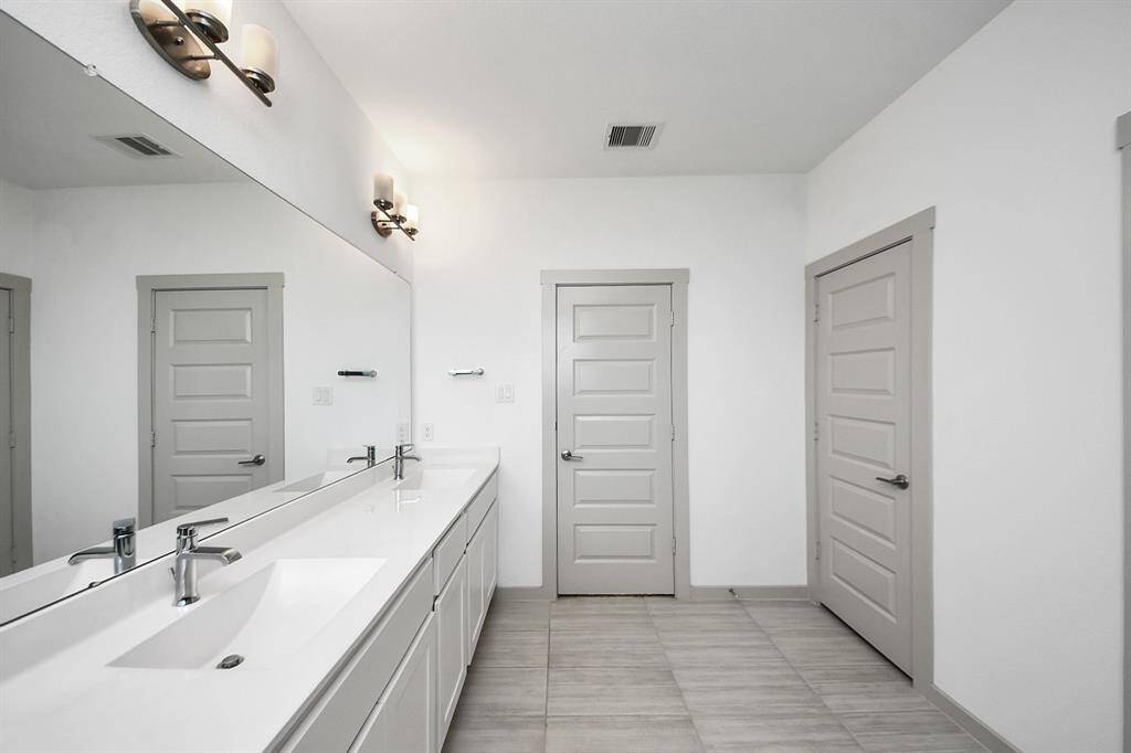 Double sinks, stunning tile work, and abundant sunlight create a luxurious oasis you'll never want to leave!