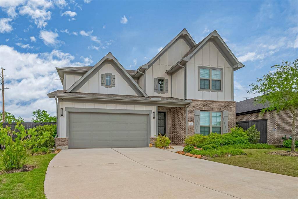 It has a spacious three-car garage and a well-maintained front yard. The driveway is wide and smoothly paved, offering ample parking space.