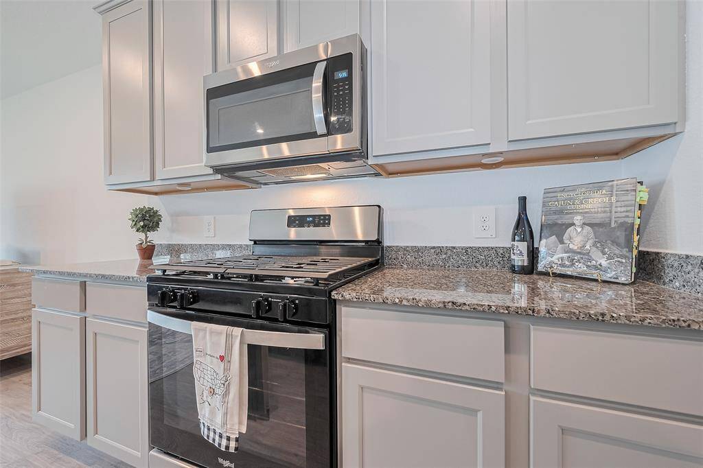 Granite countertops extend generously across the kitchen, offering ample surface area for prep work and presentation.