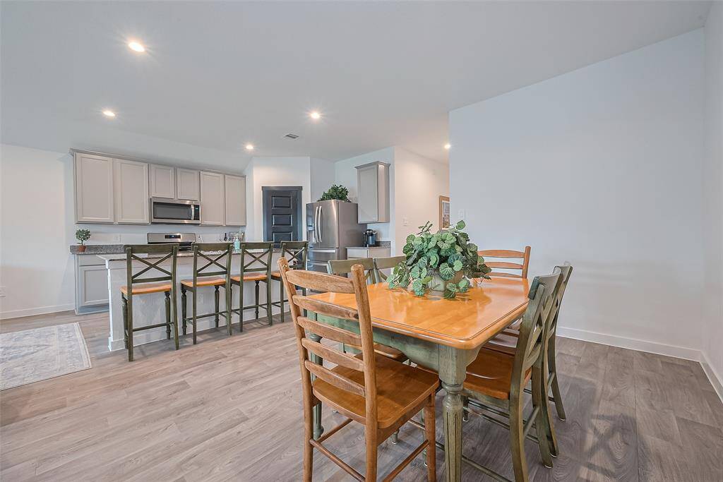 Nestled into a cozy corner, the dining area shares the same wood-look vinyl flooring that ties the main living areas together.