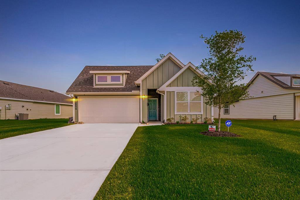 Expansive front lawn showcases lush greenery, setting the stage for the home's charming wood exterior and curb appeal.