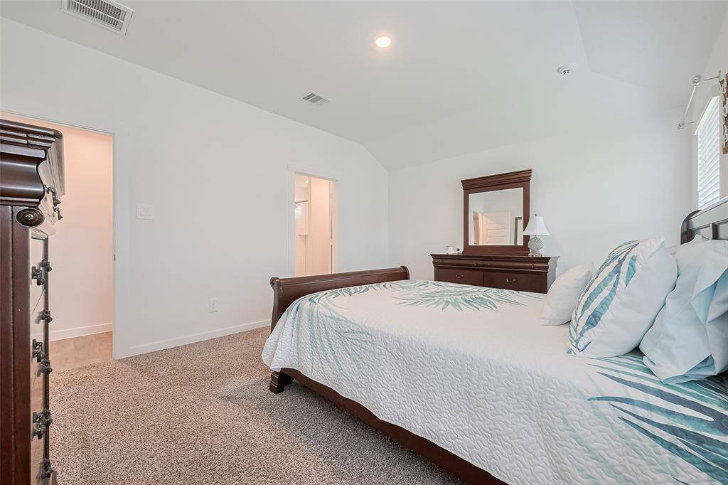 Subtle architectural detail in the gently sloped ceiling adds dimension to the primary bedroom, which connects to its own en suite.
