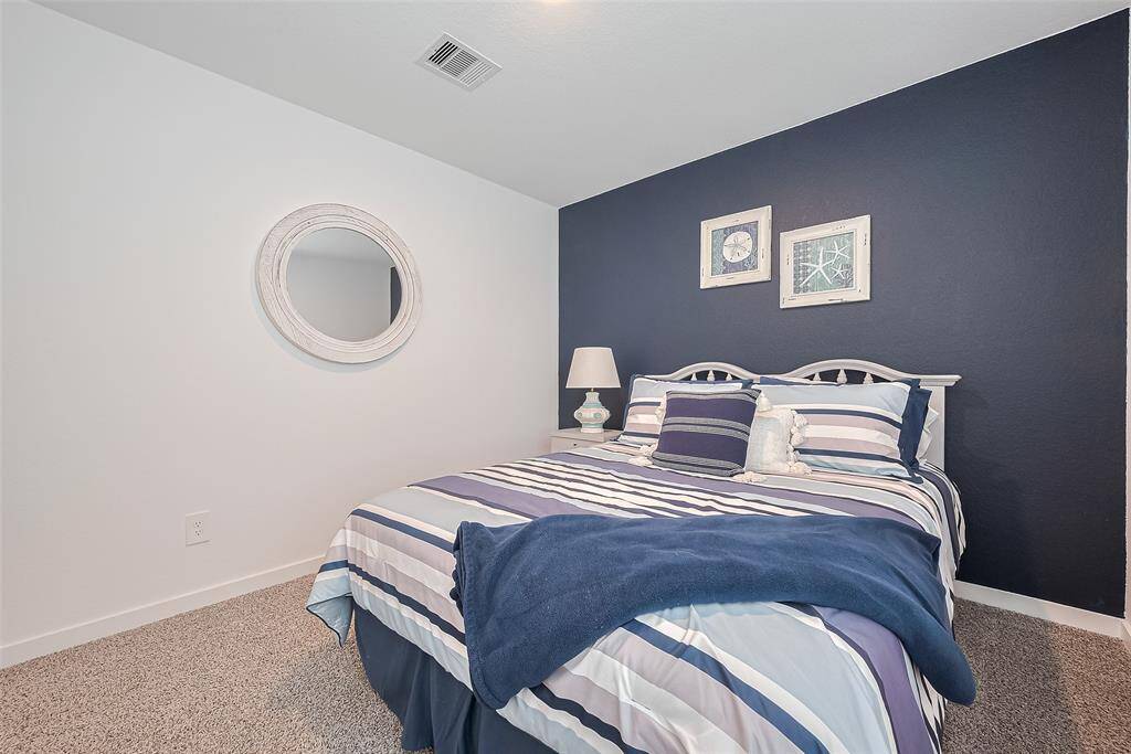 This bedroom makes a bold statement with a deep blue accent wall, contrasting beautifully against soft neutrals.