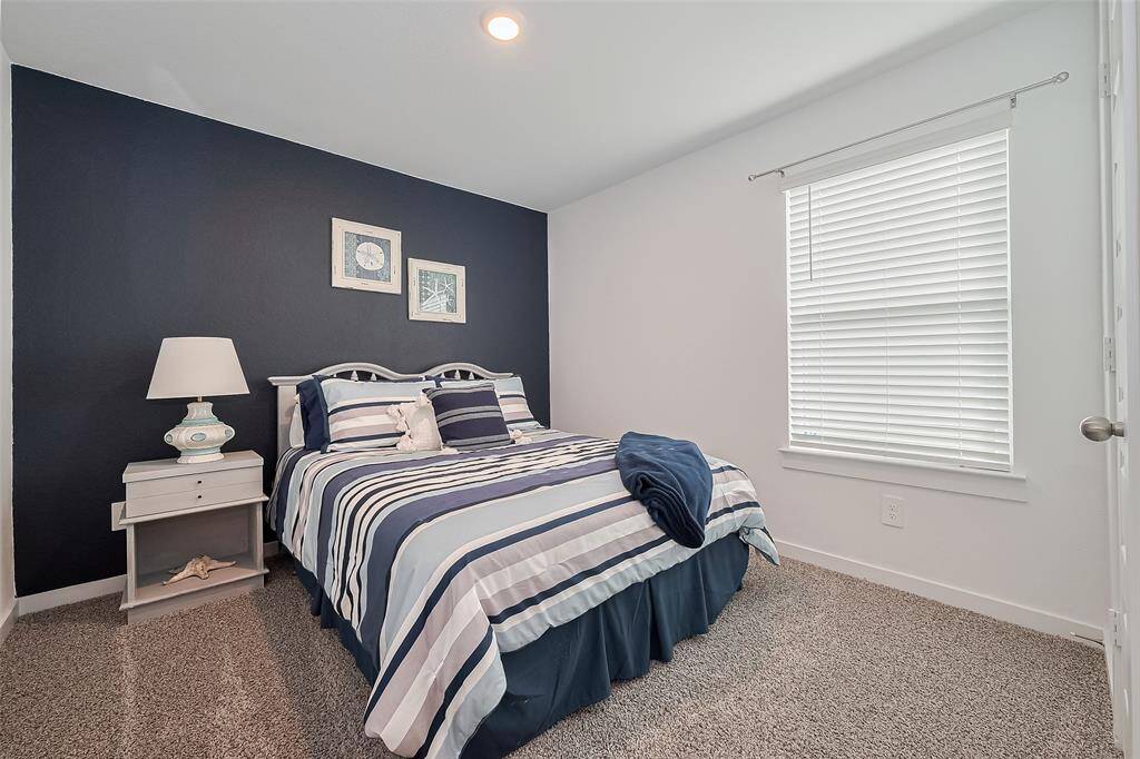 Carpeted for comfort, this bedroom also benefits from a large window bringing in natural light.