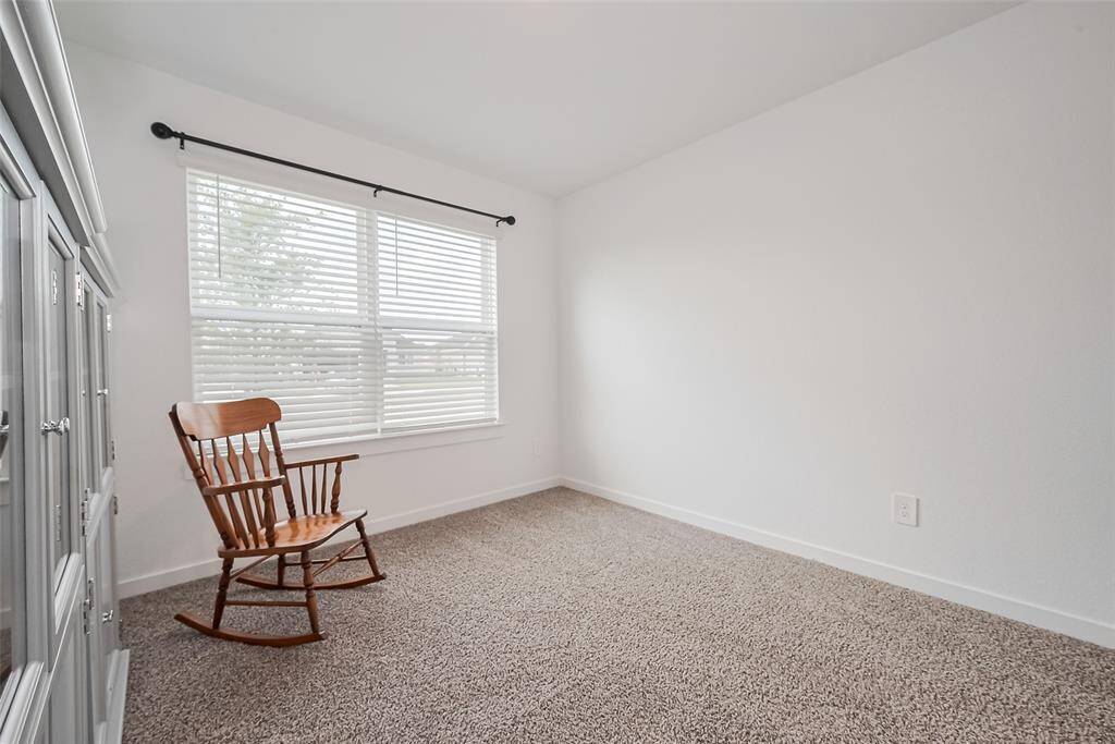 This secondary bedroom is bright and welcoming, thanks to its wide window and neutral palette.