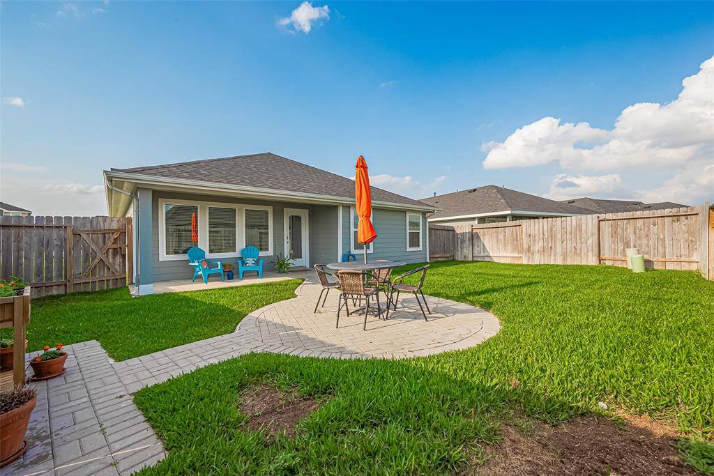 The rear view of the home is picture-perfect, with a balance of relaxing patio areas and wide-open lawn space.