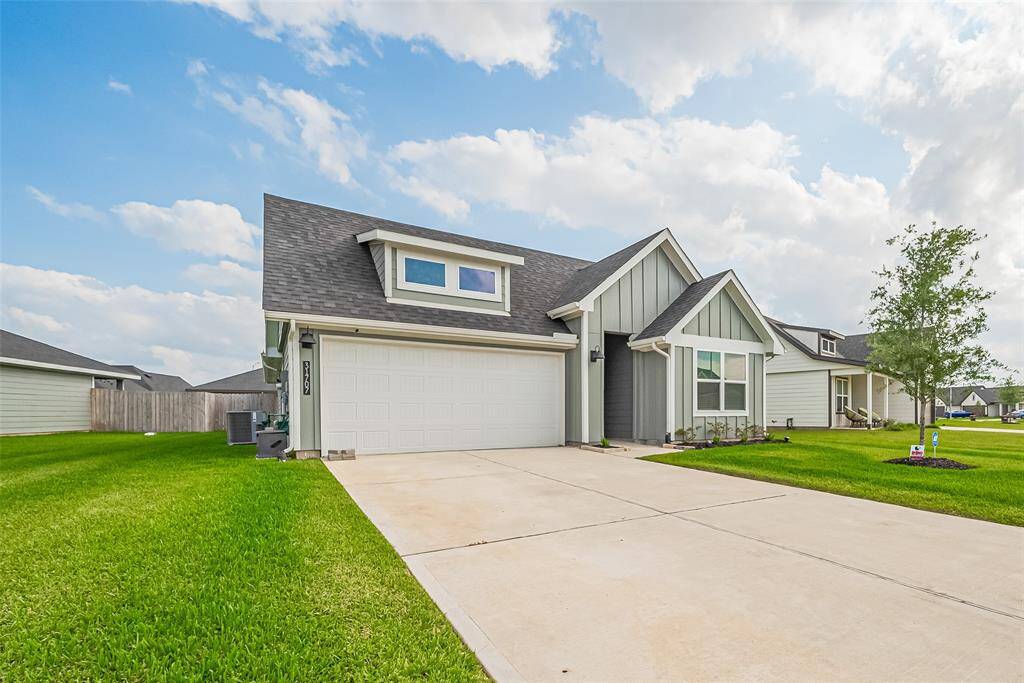 The driveway is wide and well-maintained, guiding you to the attached two-car garage with ease.