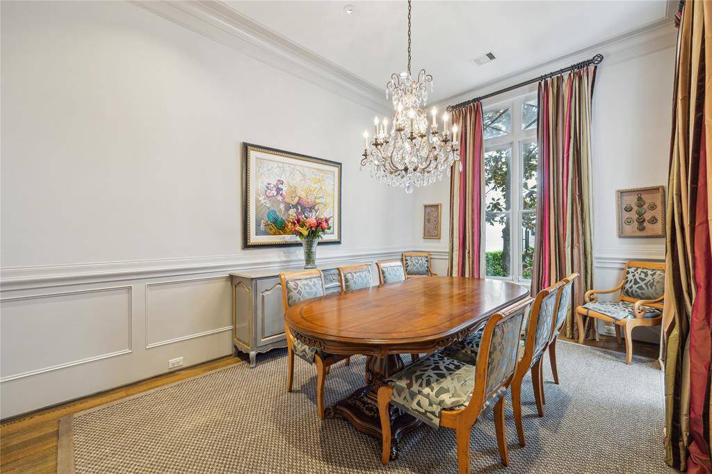 An alternate view of the dining room draws attention to the elegant chair rail detail, with the butler’s pantry conveniently located just to the left, leading toward the kitchen.