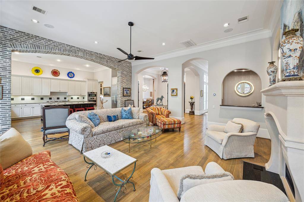 A brick accent wall with a wide opening creates a distinctive connection between the living room and kitchen, adding texture and visual interest while maintaining an open flow.