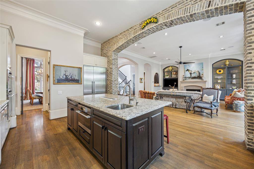 Another look at the kitchen reveals the smooth, open floorplan, with clear sightlines to the spacious living room and the staircase positioned toward the back—highlighting the home’s seamless layout and flow.