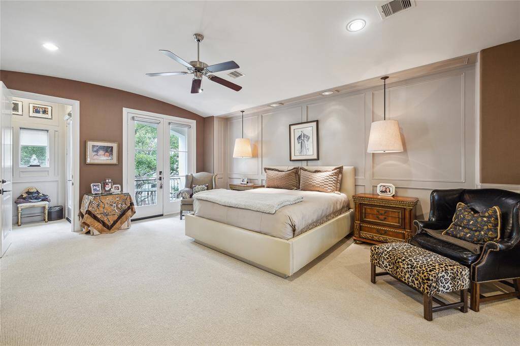 The primary suite offers a serene retreat, complete with room for a sitting area, a convenient dry bar great for morning coffee, and glass French doors that open to a private balcony overlooking the courtyard.