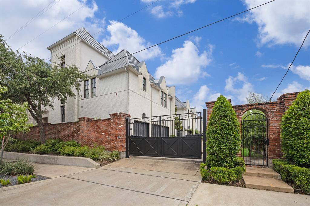 An elegant iron gate opens to a peaceful courtyard, providing a warm and inviting entry before you arrive at the front door.