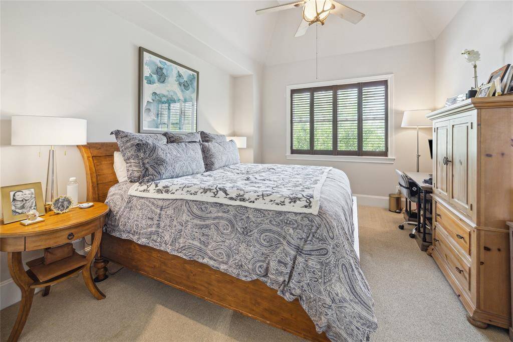 The third-floor secondary bedroom features a ceiling fan with light, an ensuite bath, and is conveniently located just off the spacious game room and wet bar.
