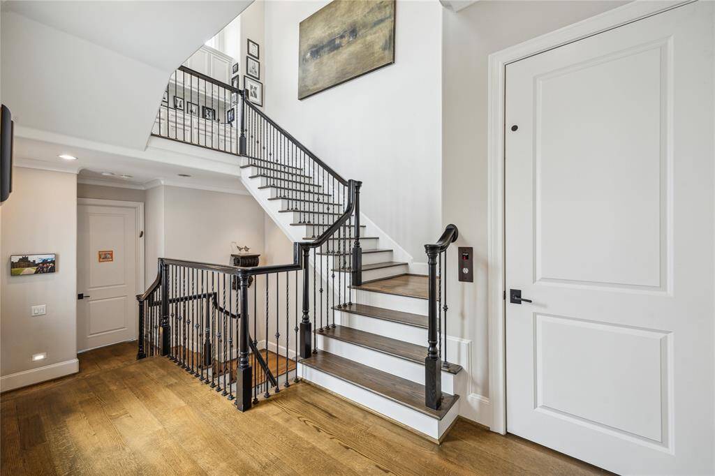 The second-floor landing features the elevator door to the right of the stairs, while to the left, you'll find the spacious secondary bedroom.