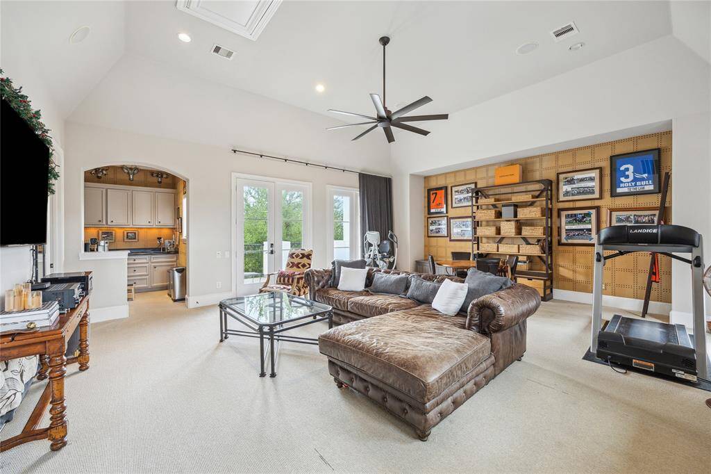 The fantastic game room offers access to a balcony as well as the rooftop terrace, a large bar area, recessed lighting, and a ceiling fan—great for entertaining or relaxing.