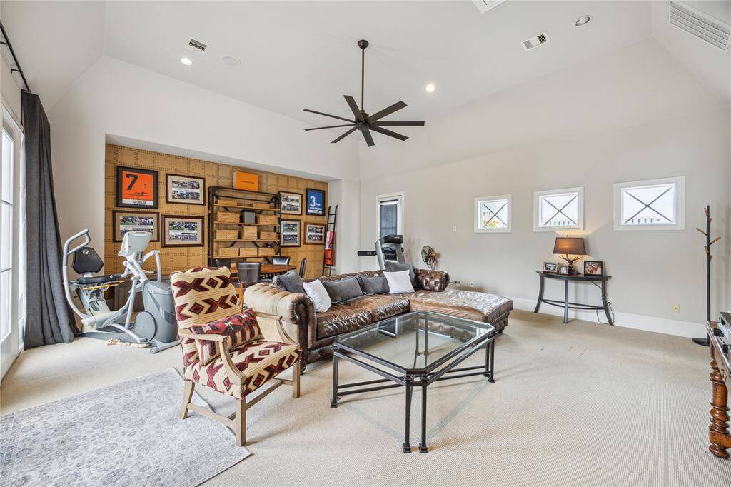 Another view of this bright and inviting game room showcases its open layout, abundant natural light, and seamless connection to the balcony and the rooftop terrace.