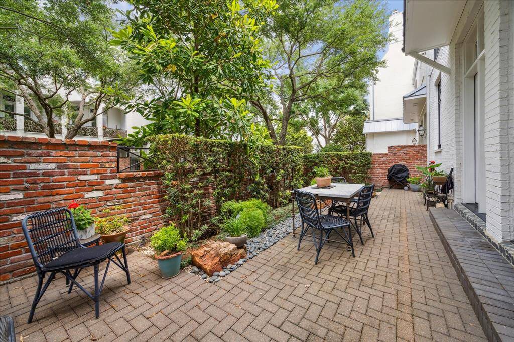 A charming brick wall lines the patio, adding both privacy and character to this peaceful outdoor space.