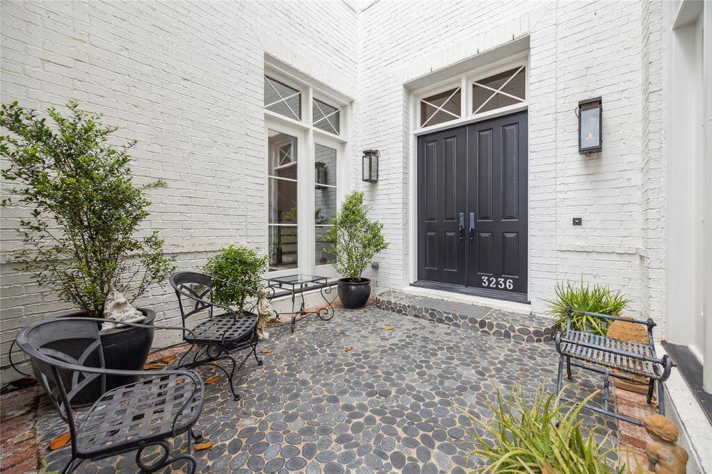 The front courtyard, finished with attractive pebble stone, offers space for outdoor seating and provides a peaceful spot to relax and enjoy the outdoors.
