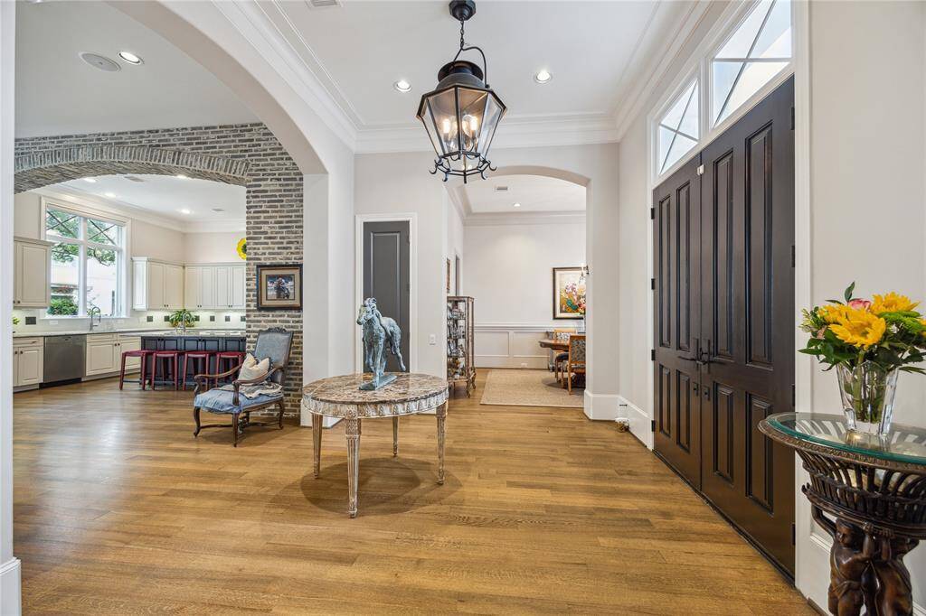 The entry welcomes you with handsome wood doors accented by transom windows, setting the tone for the home’s refined style. As you step inside, you’re greeted by beautiful wood floors that extend throughout the main living areas.