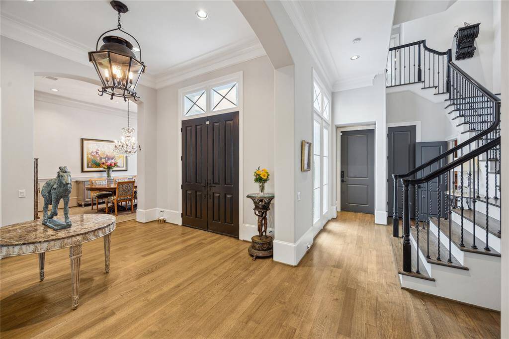 The staircase, featuring stylish iron balusters and wood railing, is bathed in natural light from the large nearby windows, creating an open and airy feel as you move between levels.