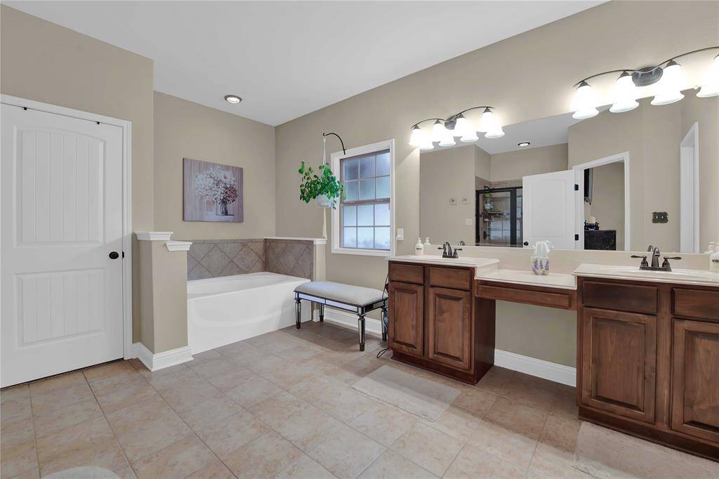 Primary bathroom with double sinks and a vanity sitting area