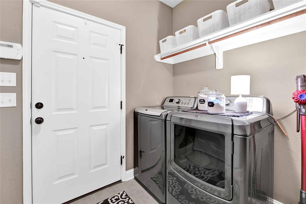 Laundry room with shelving and cabinets