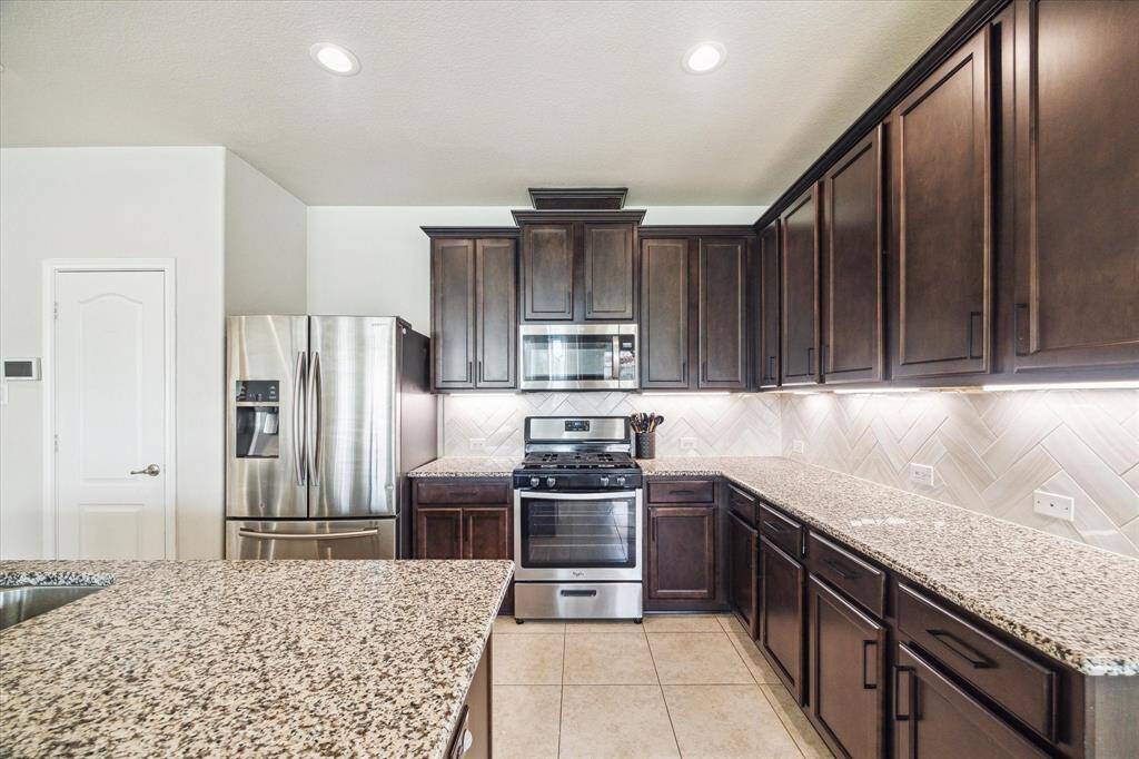 Look at all that beautiful counter space! Just to the left of the refrigerator is your walk in pantry with wood shelving - upgraded from the original wire rack shelving!