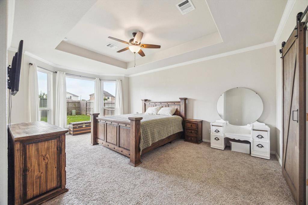 Welcome to the primary suite featuring crown molding, bay window, and plenty of room for your bedroom furniture and a sitting area if you so desire!