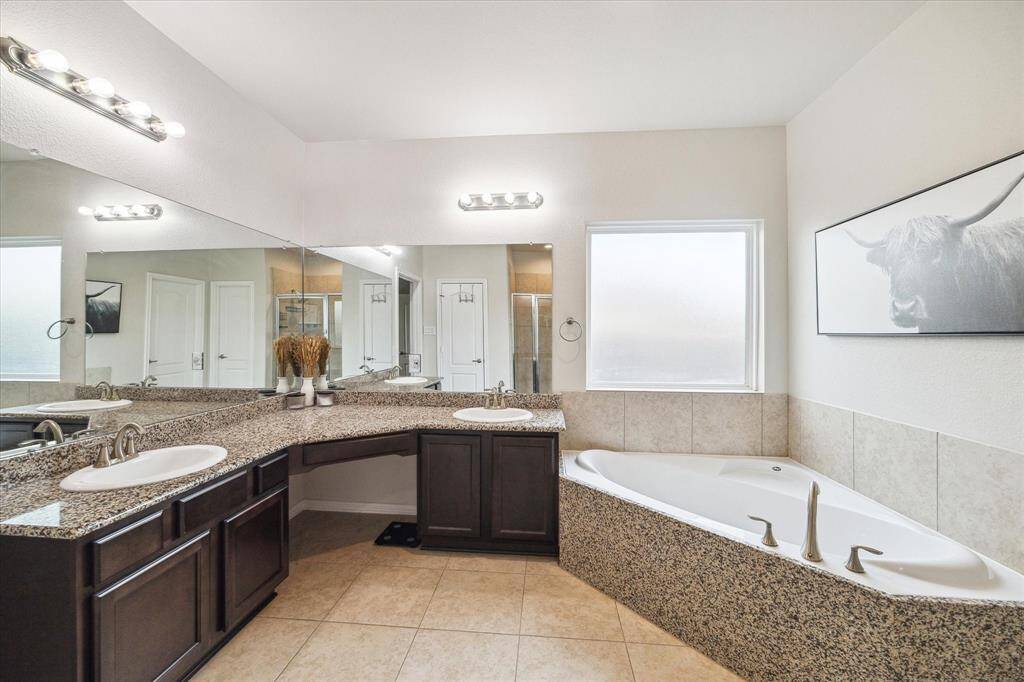 The primary bath features a dual vanity, soaking tub, and separate shower. The house has an electric tankless water heater for near instant hot water as well as being upgraded with a whole house water softener!