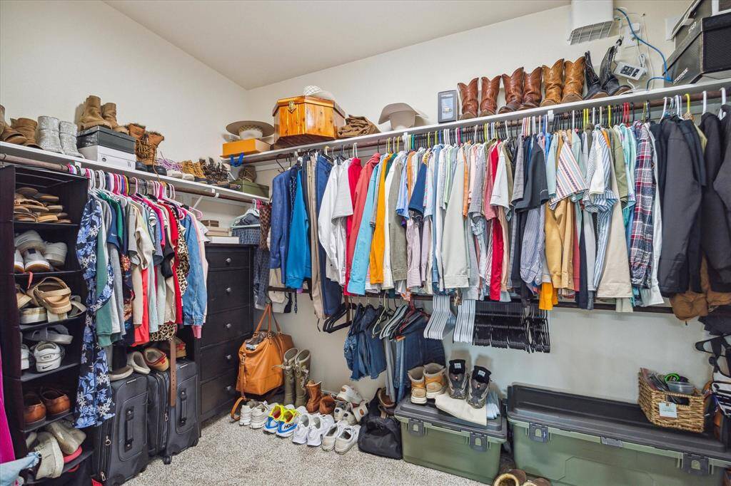 This primary walk in closet also features upgraded wood shelving & more than enough storage space!