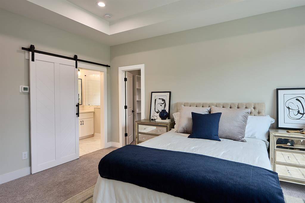 Another view of the primary bedroom with the barn door that leads into the primary bathroom.