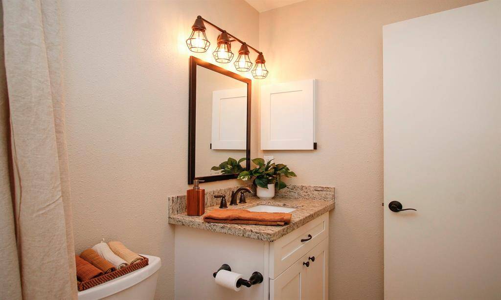 The full Bath also offers updated light and plumbing fixtures, an attractive mirror, and an undermount sink.