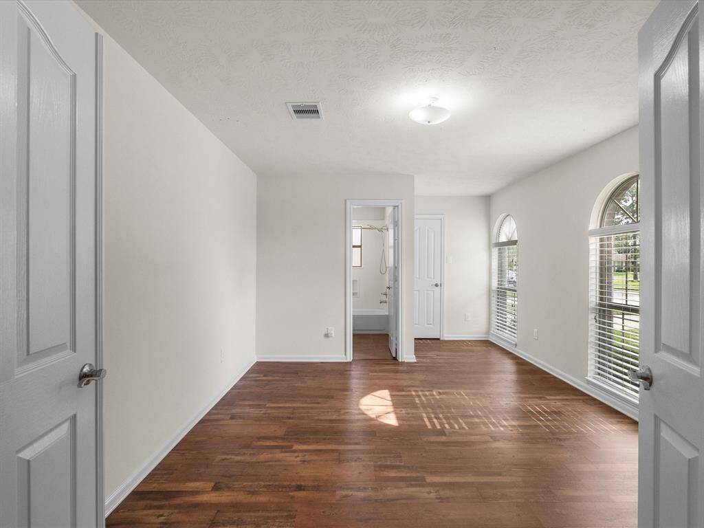 In demand and desirable secondary primary suite features beautiful front windows with natural light to flood the space with cheerful vibes each day!  Full bathroom, closet and double-door, built-in shelving for convenience.