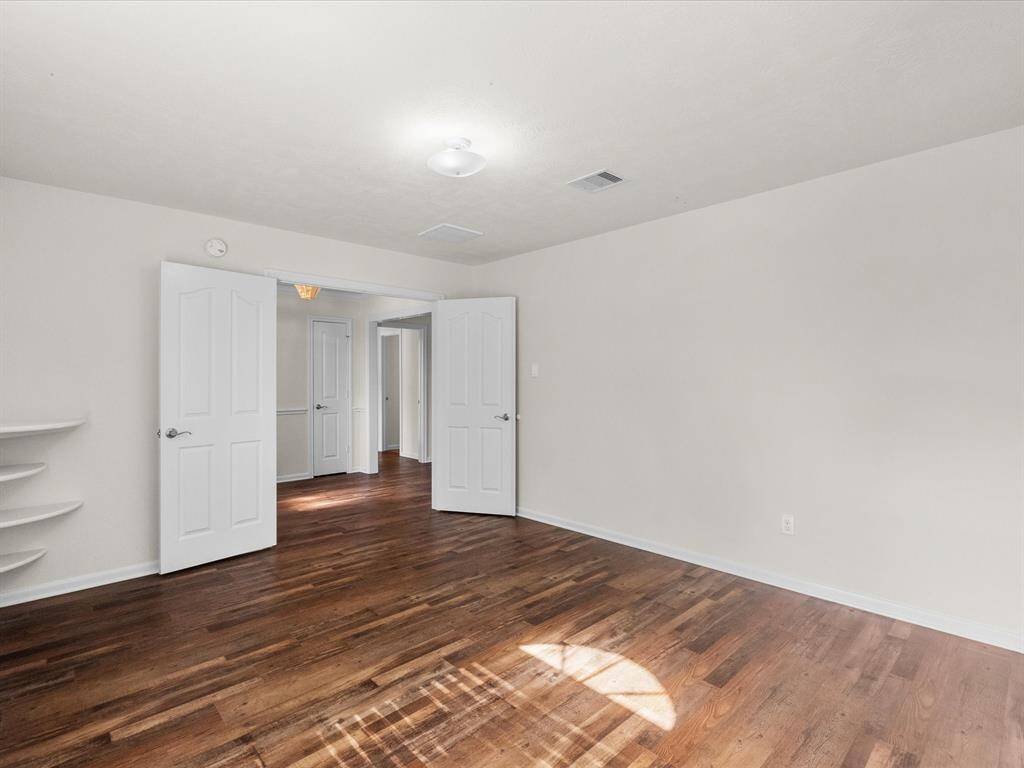 Double doors and view to foyer from secondary primary suite.  Spacious and desirable, this room offers privacy and is situated at the front of the home for a quieter ambiance when needed.