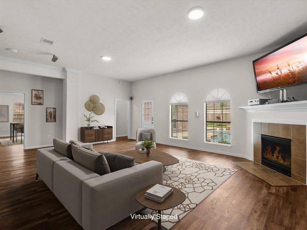 Virtually staged living room suggests a furniture layout that enjoys the amazing view of the pool and backyard and a relaxing and easy view of fireplace and television.