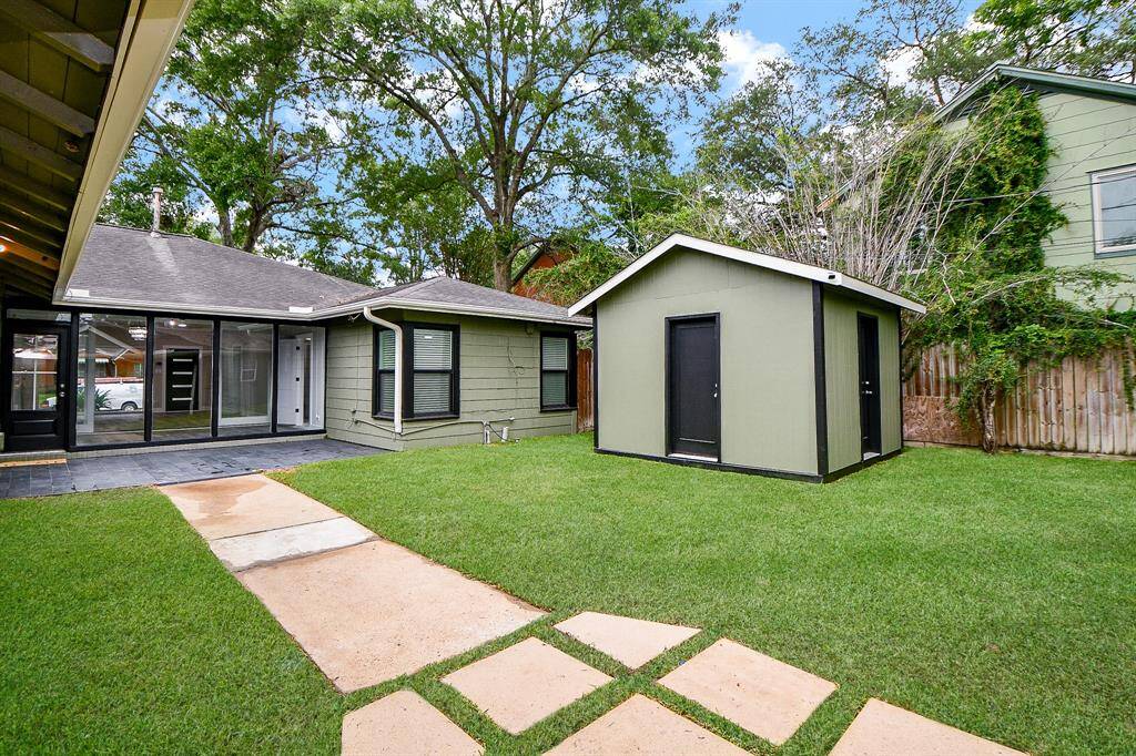 Charming backyard with a lush green lawn perfect for outdoor relaxation and entertainment.