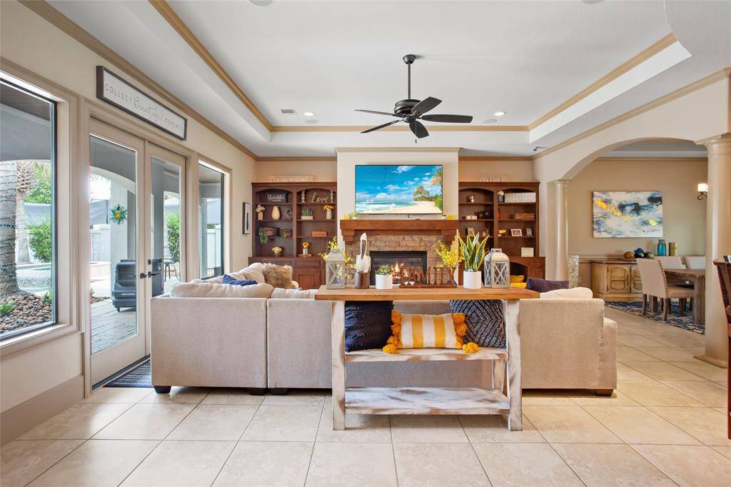 Large family room with stacked stone gas fireplace and solid wood built ins and surround sound system.