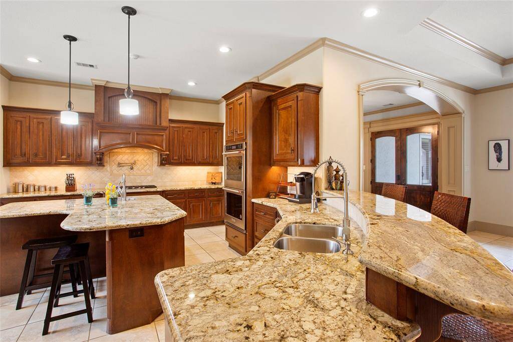 Solid wood custom cabinets with wrap around breakfast bar and additional seating at the kitchen island.