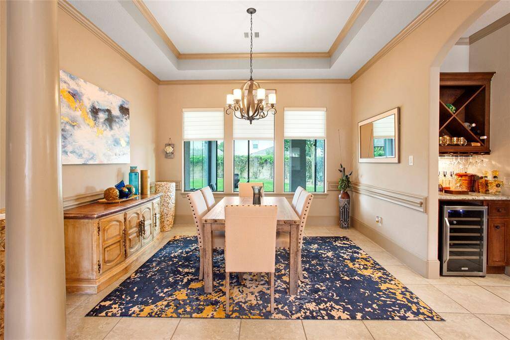 Formal dining room off kitchen with chair rail, crown molding and tray ceiling with plenty of room for a large table, buffet and hutch.