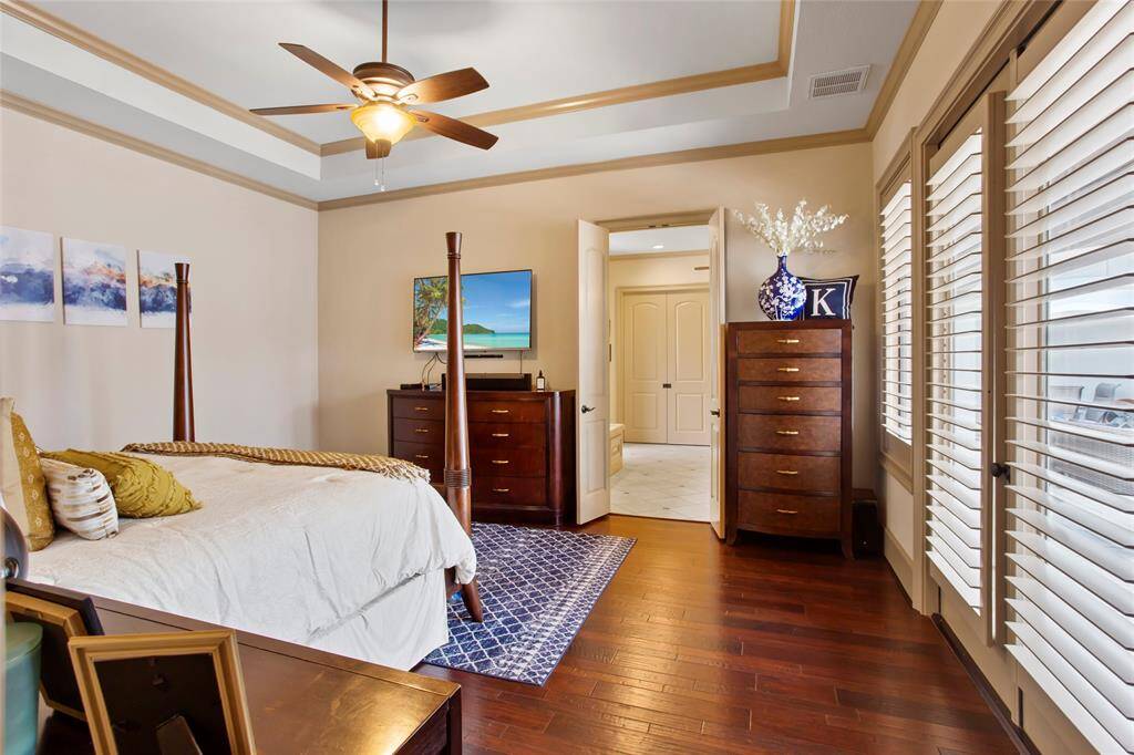 Primary bedroom down with solid wood flooring.