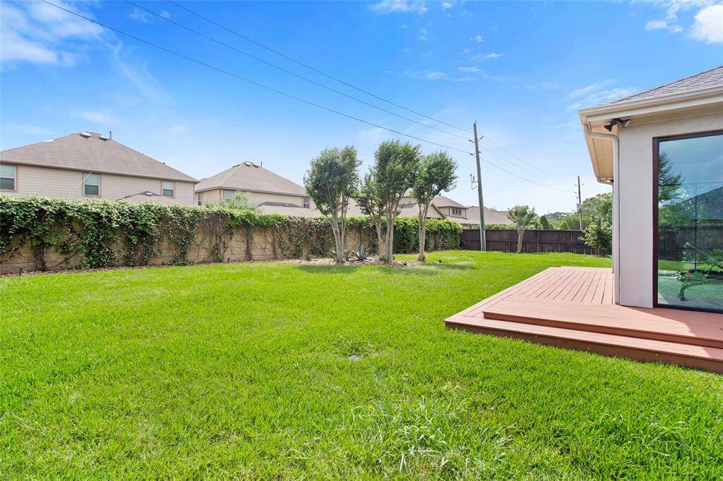 Spacious backyard with concrete privacy fence in back. Wood fence was replaced after this photo in May 2025.
