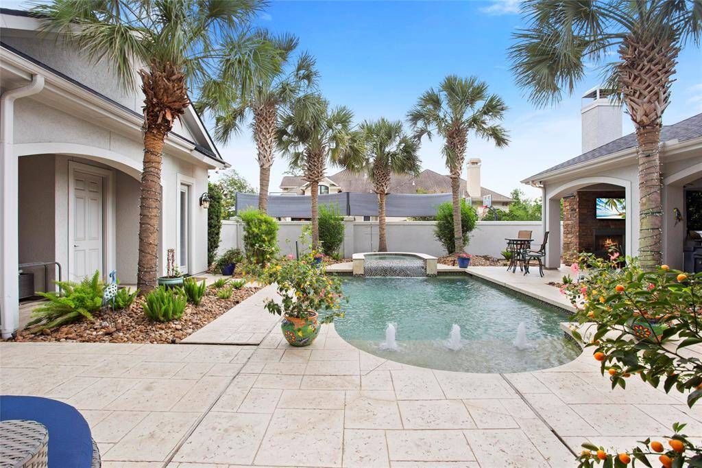 Heated pool and cascading waterfall spa surrounded by tropical landscaping plus lemon and tangerine trees, completed with added (April 2025) Wireless LED Smart uplighting you control from your phone.