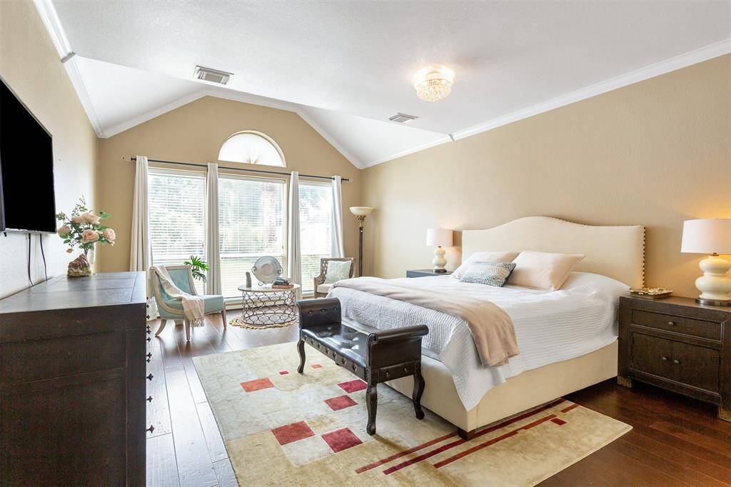 Discover the expansive primary bedroom featuring a cozy sitting area, soaring ceilings, and stunning views of the backyard flower garden.